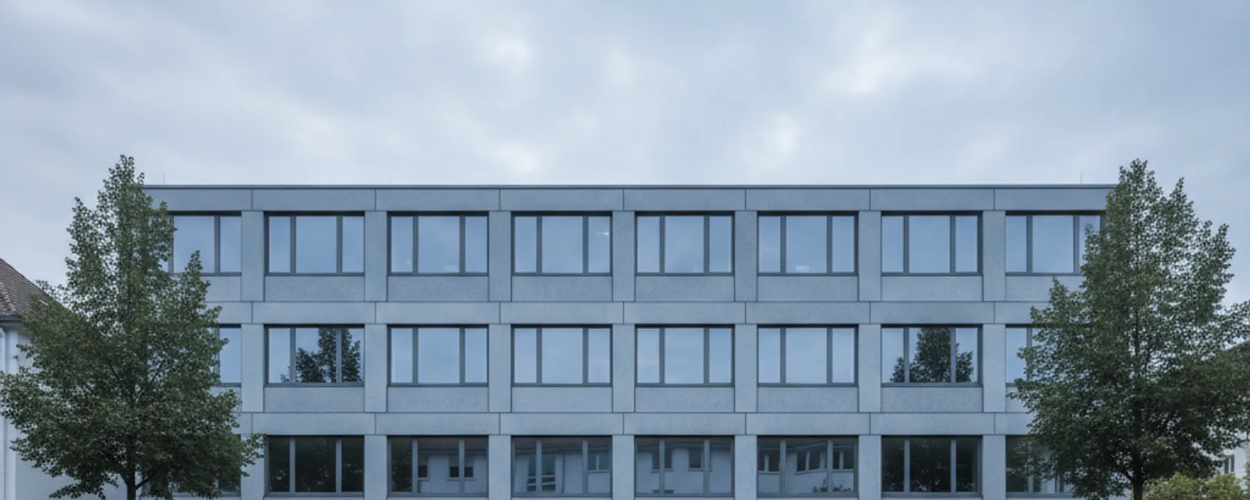 Nüchterne Bürofassade in einer ruhigen Strasse in Heusenstamm im Morgenlicht