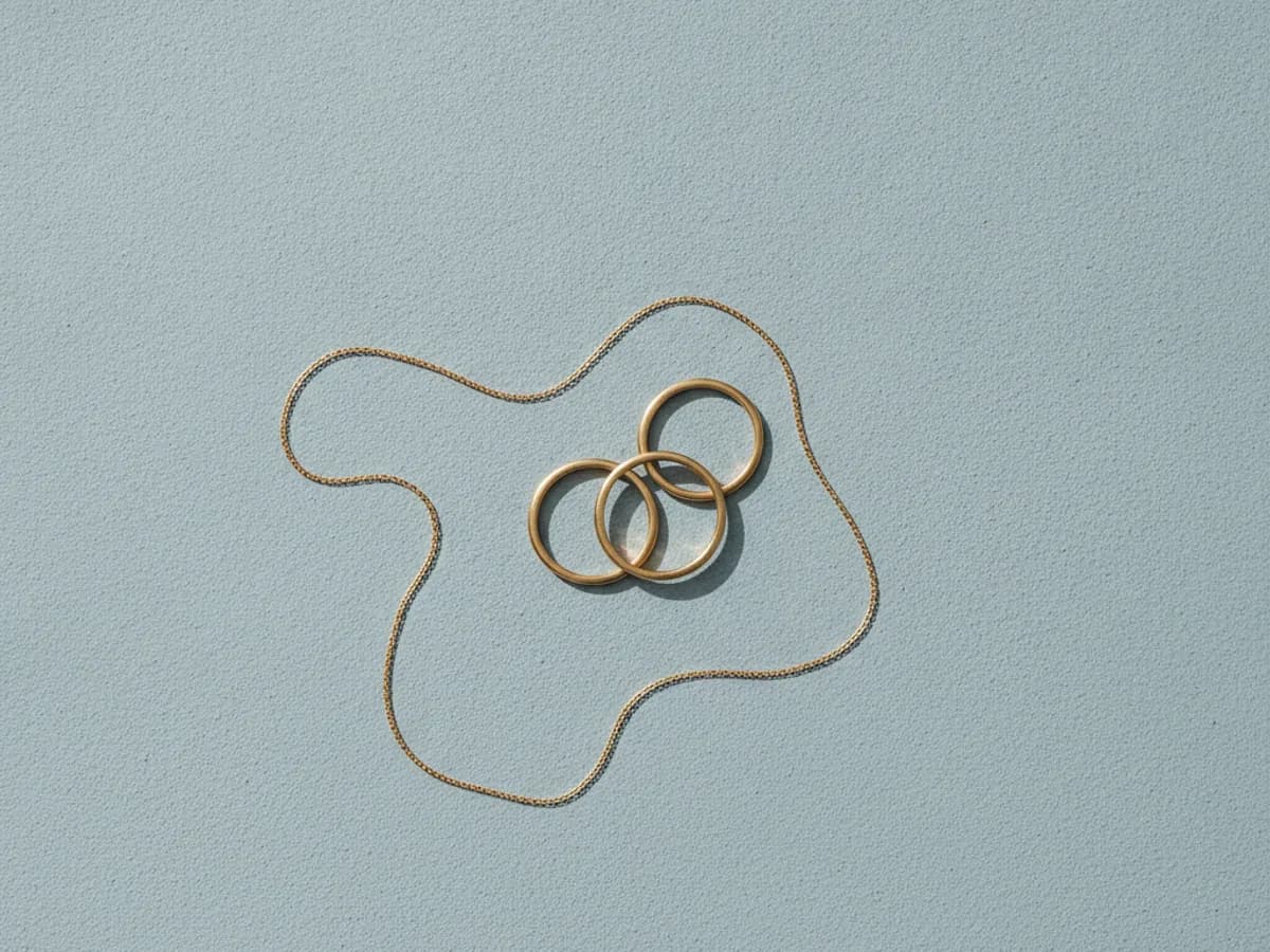 Schlichte Goldringe und eine Kette in ruhiger Ablage